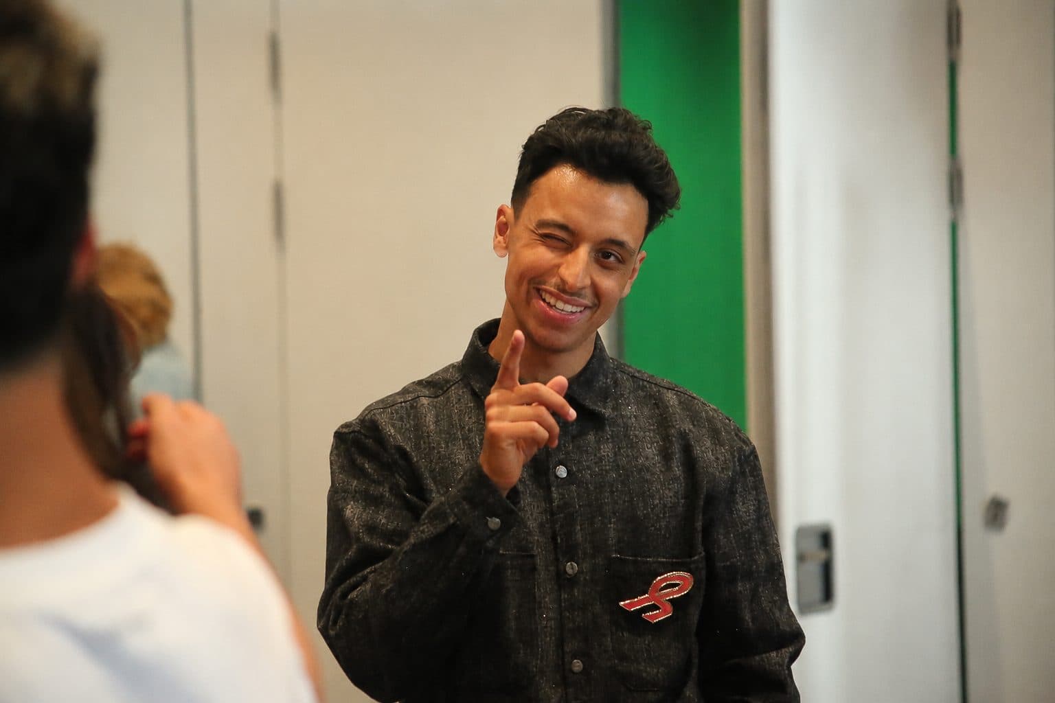 Bilal knipoogt en wijst lachend naar de camera